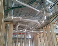 Pipe lagging installed to complex plumbing outlet system on multi-residential development.